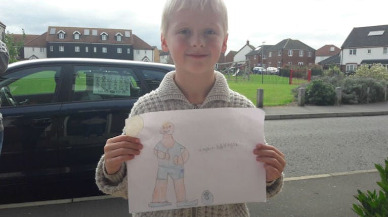 7-year-old Hayden holding up his drawing