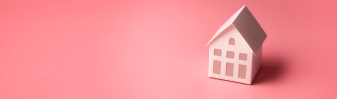 Toy house on pink background
