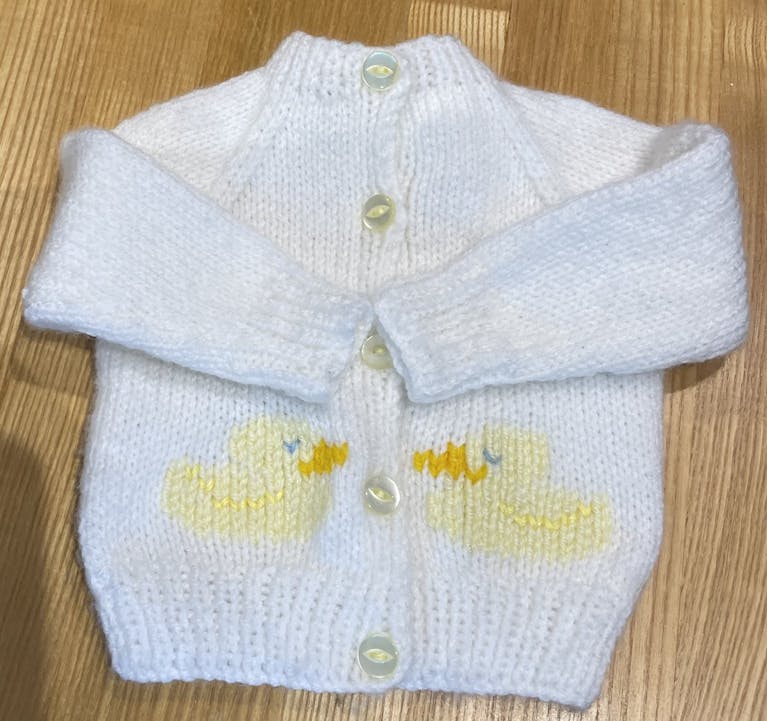 Knitted baby cardigan with duckling decoration