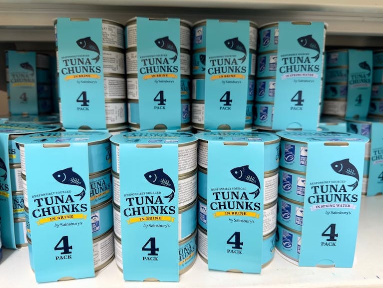 Multipacks of tuna stacked on a shelf.