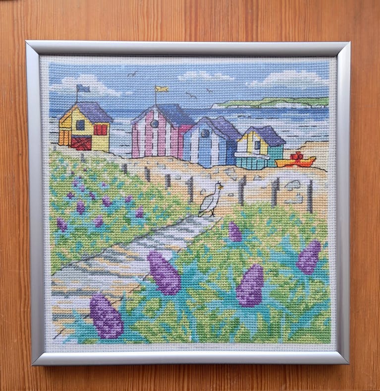 Photo of cross stitch artwork featuring beach huts