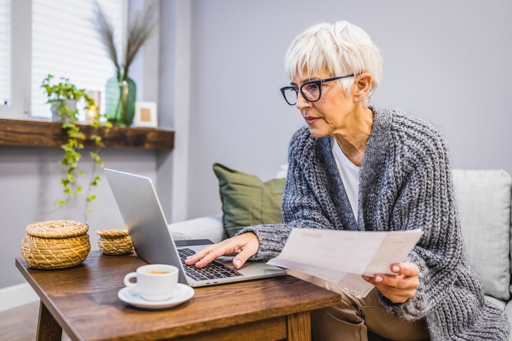 Person on laptop holding a payment card