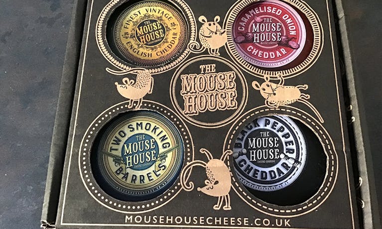 A bos labelled 'The Mouse House' with four cheese inside
