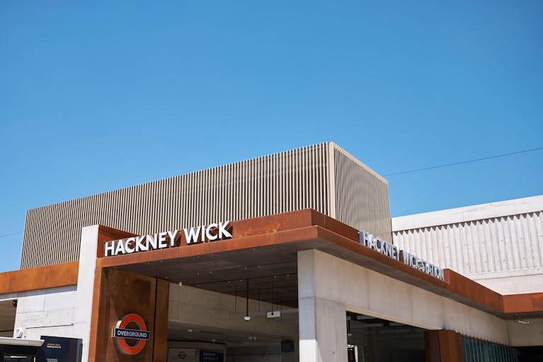 The clean, sharp lines of Hackney Wick's station exterior against a perfectly clear blue sky