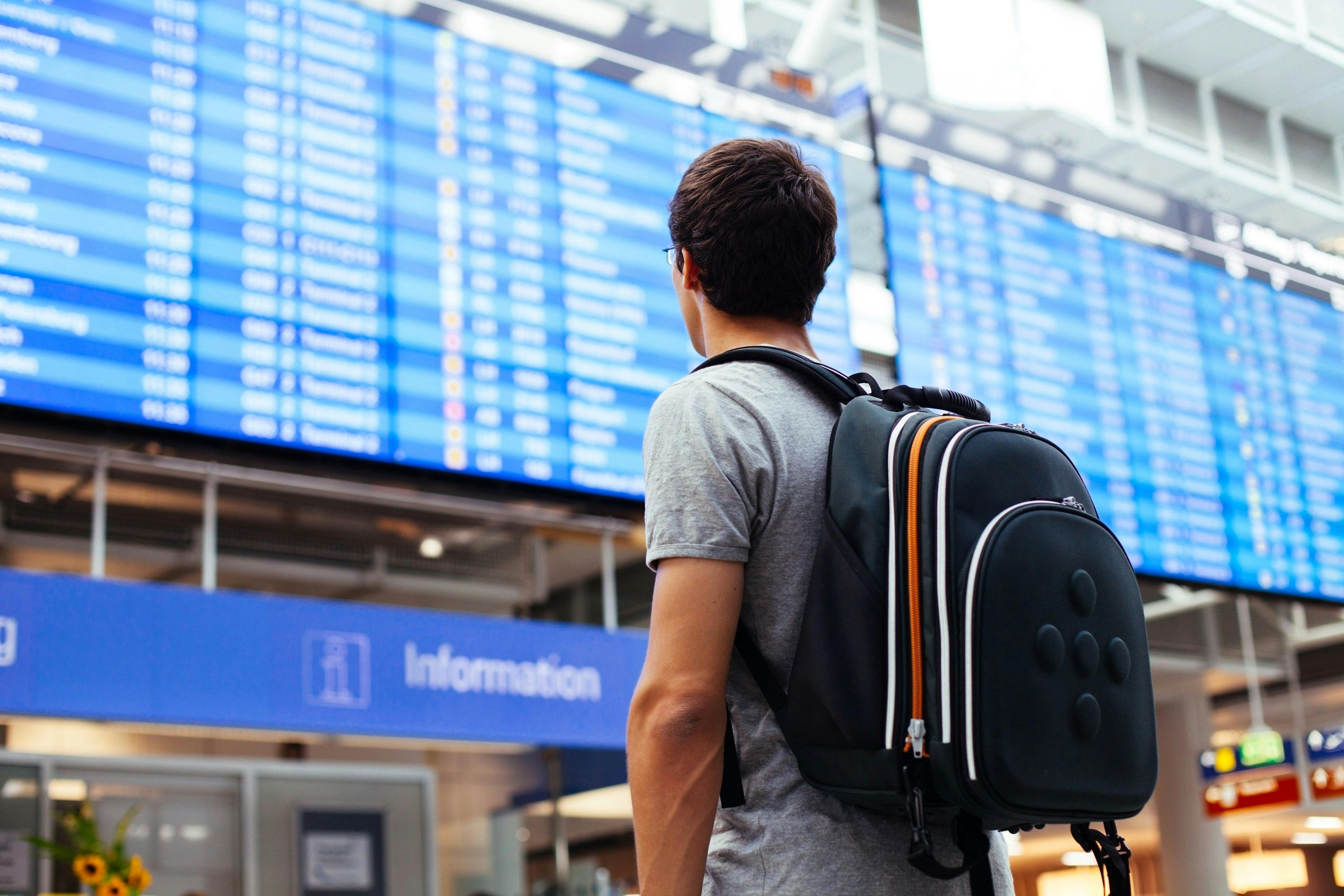 Man with backpack checking train times