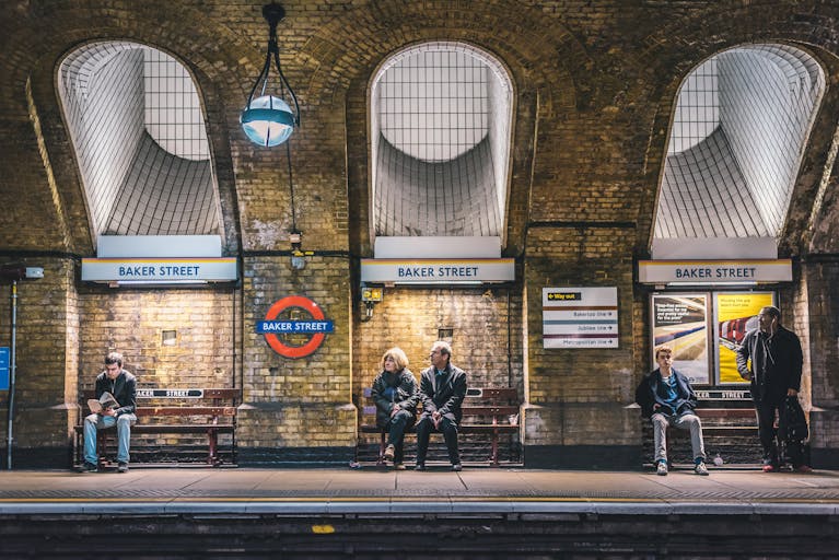 People waiting under the historic, moody Baker Street brickwork