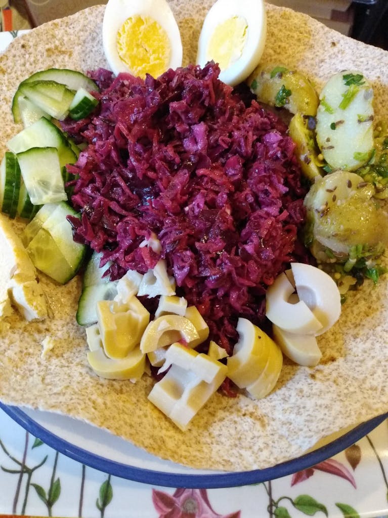 homemade coleslaw, homemade potato salad, a hardboiled egg, cucumber and a bamboo shoot