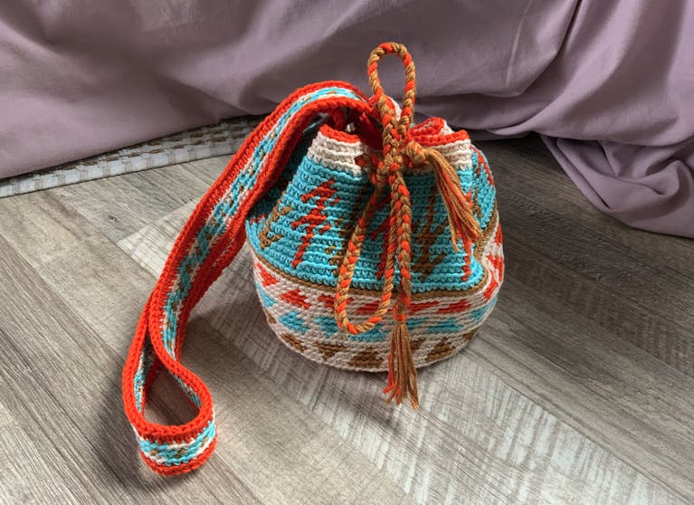 A woven bag in red, brown, cream and blue