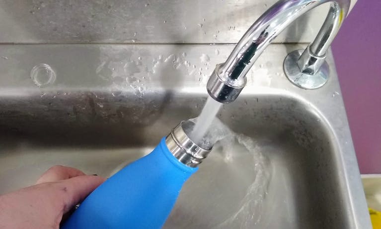 Filling a bottle from a water fountain at Gatwick.