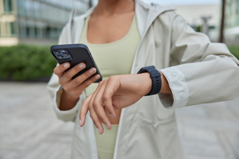 Woman looking at her phone and smartwatch