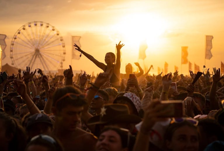 A crowd at a festival at sunset