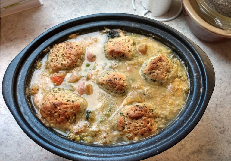 A black bowl containing dumpling stew