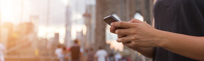 Phone in hands with the background of a city