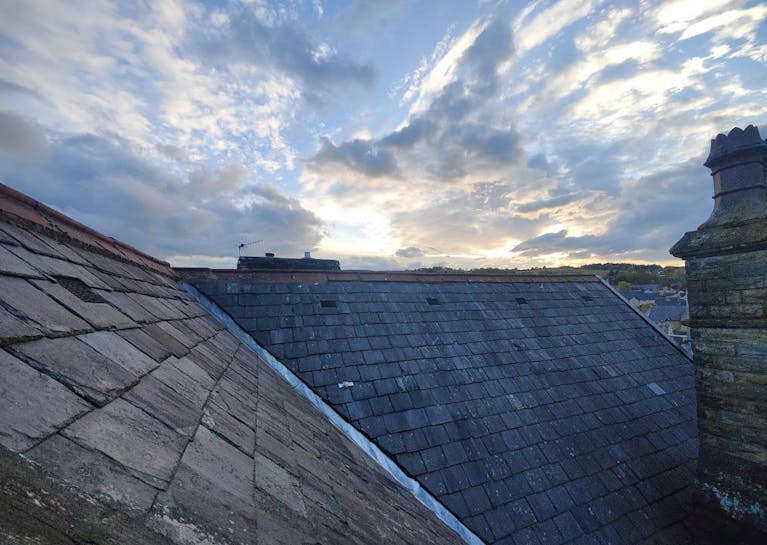 Roofs below a pretty, cloudy blue sky