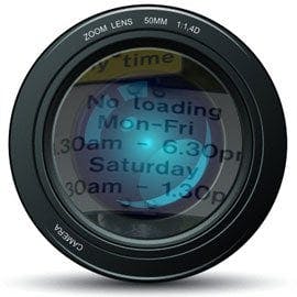 Camera lens with a parking sign reflected in it.