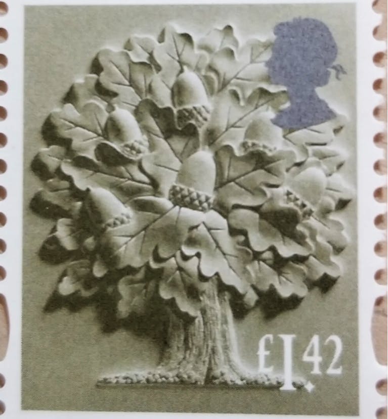 A postage stamp showing an impressionistic picture of an oak tree, with giant acorns