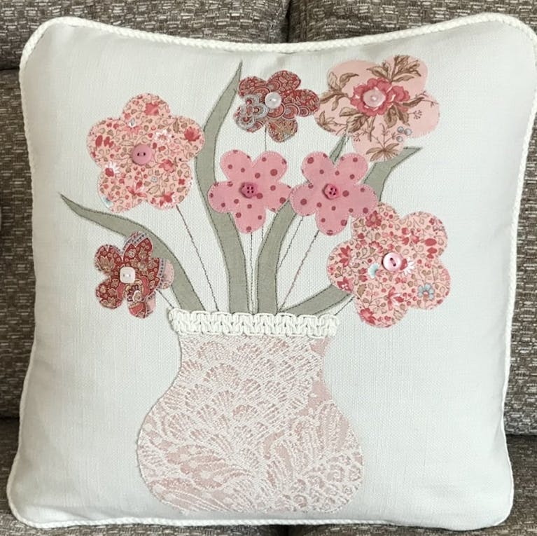 A cushion embroidered with flowers in a vase