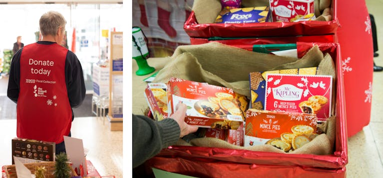 A foodbank volunteer in a Tesco bib and two boxes full of mince pies and biscuits