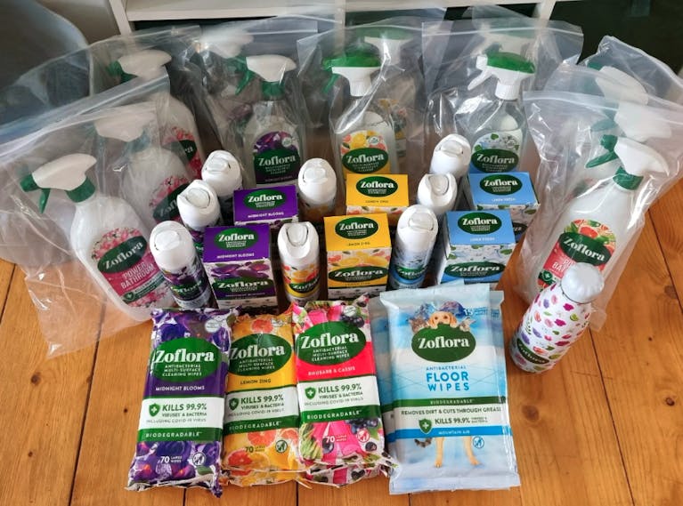 Lots of Zoflora sprays and other Zoflora cleaning products arranged on a wooden table