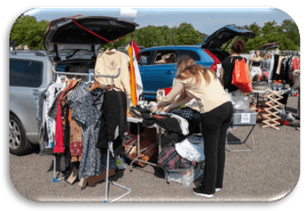 Image showing a person laying out clothes to sell on a table, and clothes hanging up on a clothes rail