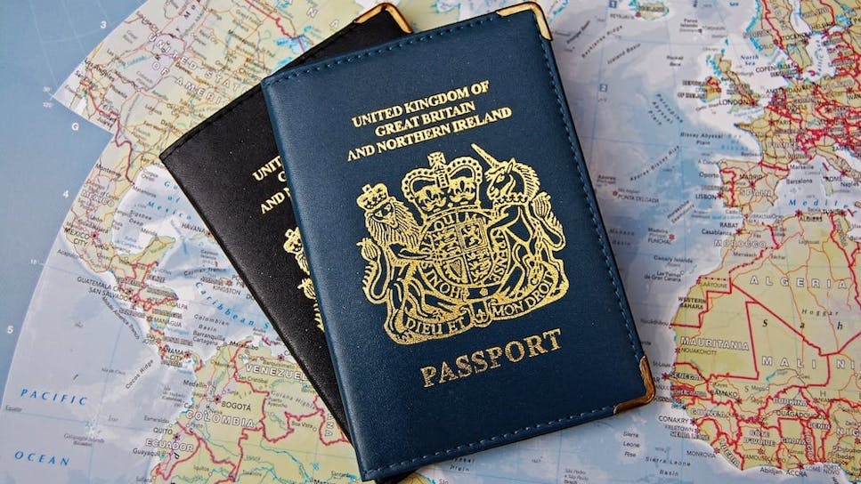 British passports on a map. The top-most passport reads: