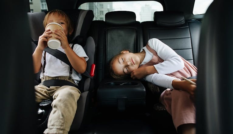 A girl and a boy in the backseat of a car