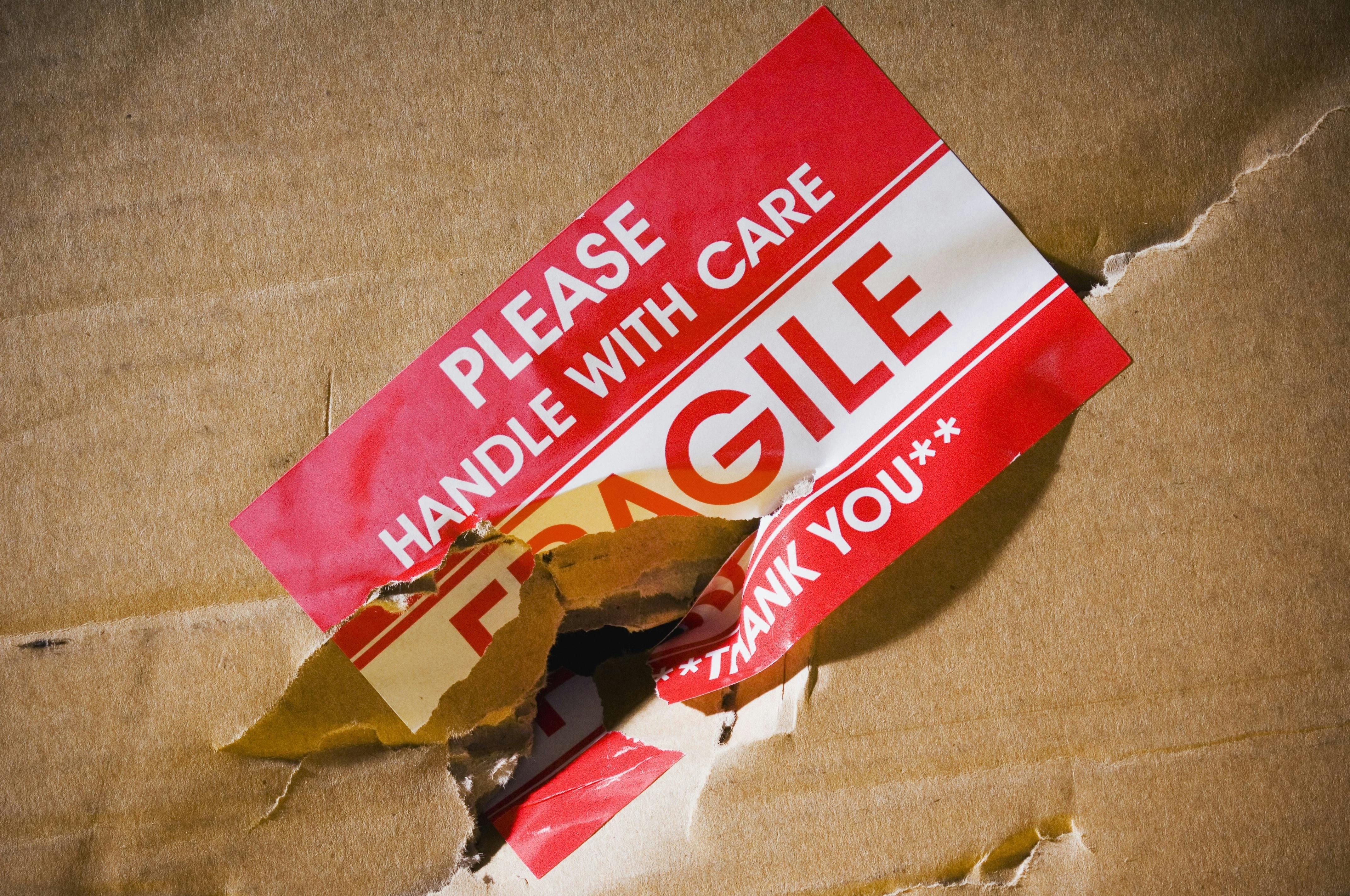 Damaged box with a label reading, "please handle with care. Fragile".