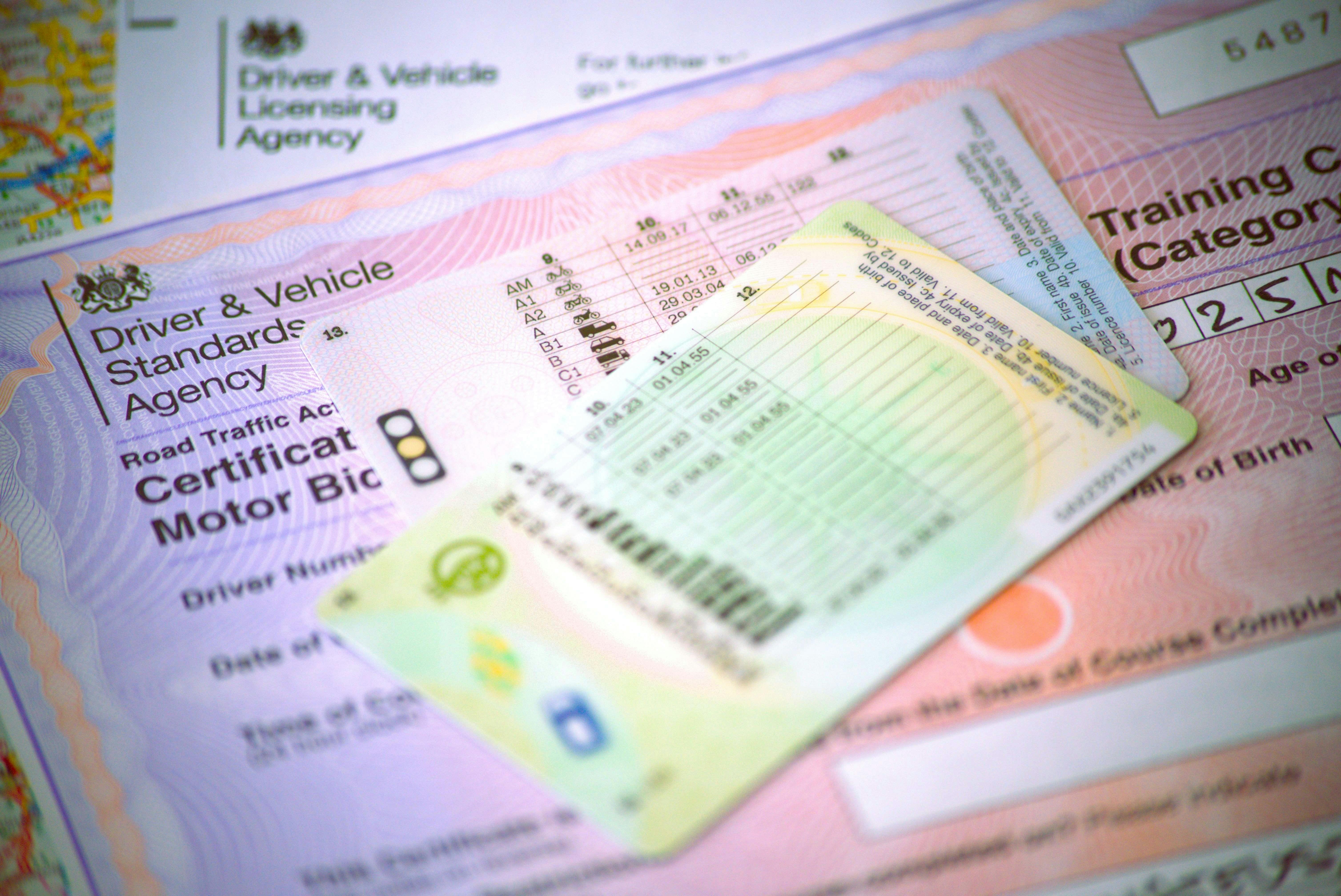 Two driving licences and other associated documentation, with one reading "Driver and Vehicle Standards Agency".